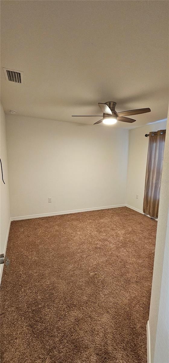 unfurnished room featuring visible vents, carpet flooring, a ceiling fan, and baseboards