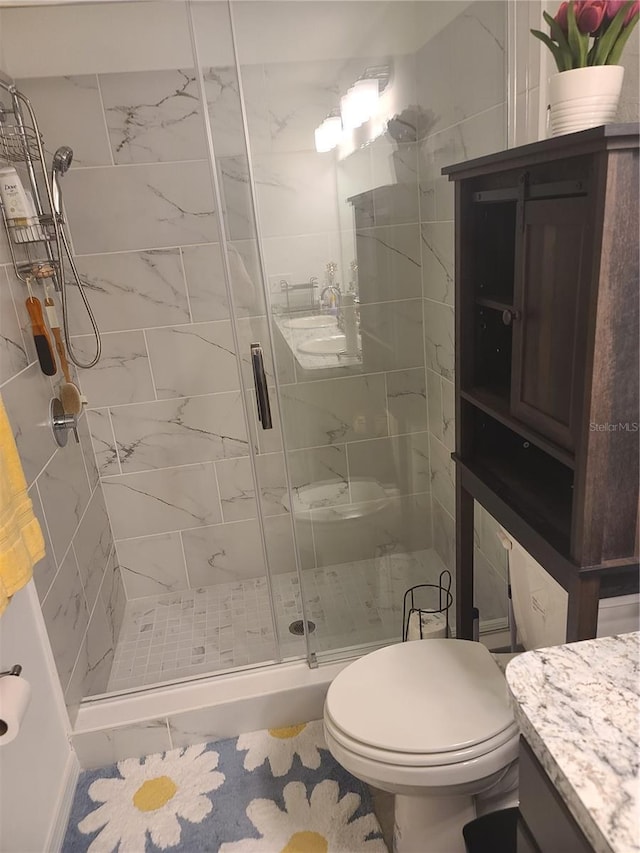 bathroom with a shower stall, vanity, and toilet