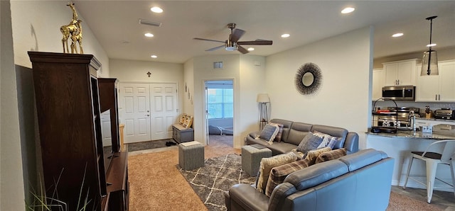 living room with carpet floors, recessed lighting, visible vents, and a ceiling fan