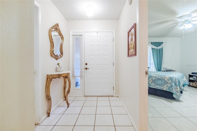 foyer entrance featuring light tile patterned floors and a textured ceiling