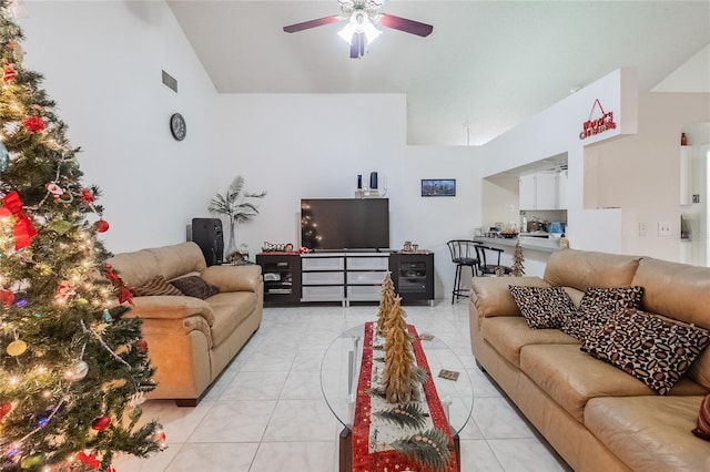 living room with ceiling fan, vaulted ceiling, and light tile patterned flooring