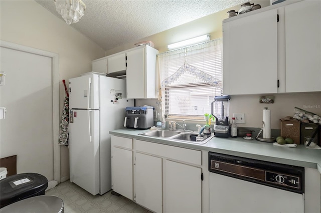 kitchen with lofted ceiling, white fridge, sink, white cabinetry, and dishwashing machine