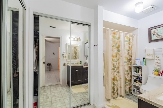 bathroom featuring curtained shower, toilet, and vanity