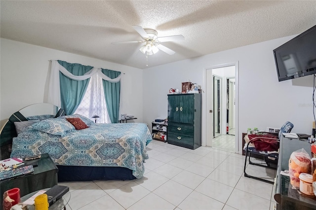 tiled bedroom with a textured ceiling and ceiling fan