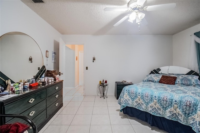 bedroom featuring ceiling fan, a textured ceiling, and light tile patterned floors