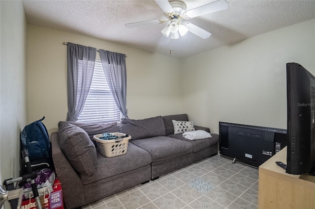 living room with a textured ceiling and ceiling fan