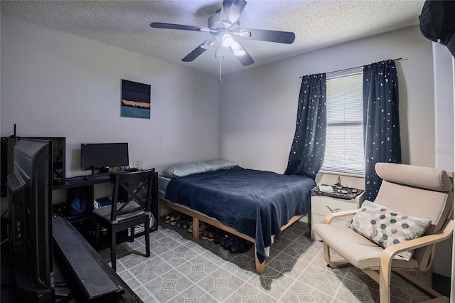 bedroom featuring ceiling fan and a textured ceiling