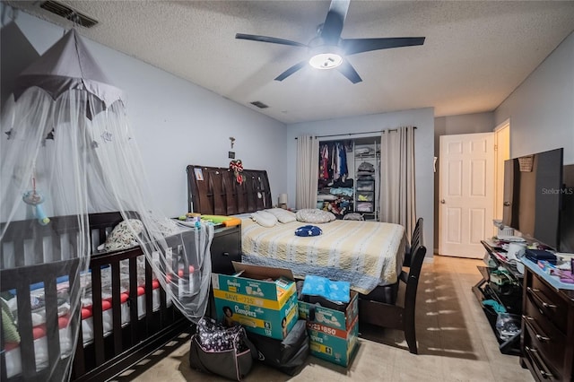 bedroom with ceiling fan and a textured ceiling