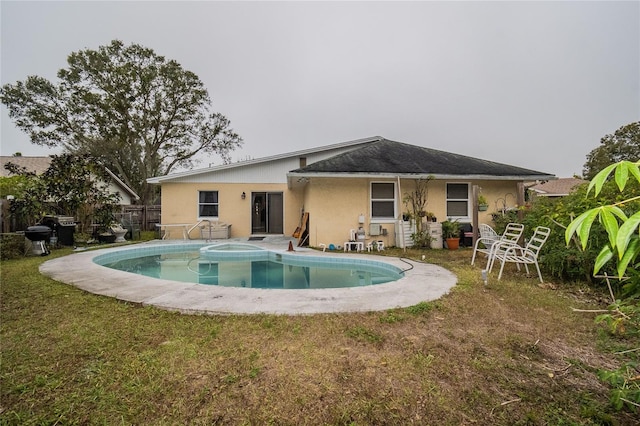 back of house with a fenced in pool and a lawn