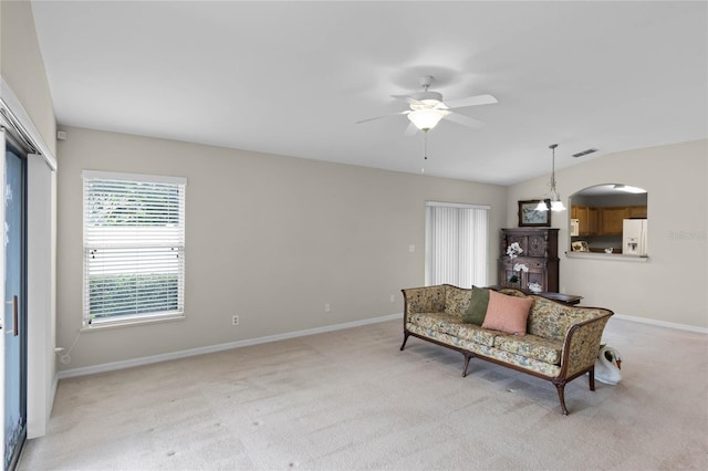 living area with ceiling fan, light colored carpet, and lofted ceiling