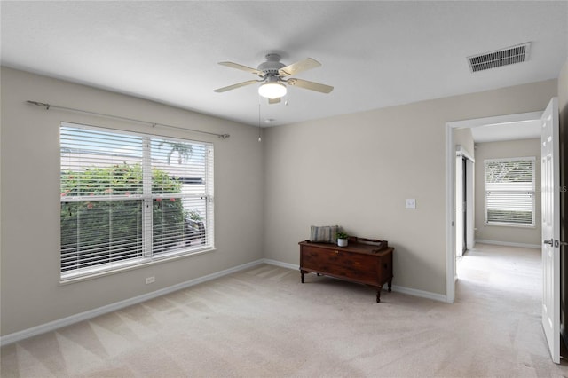 unfurnished room with light carpet, ceiling fan, and a healthy amount of sunlight