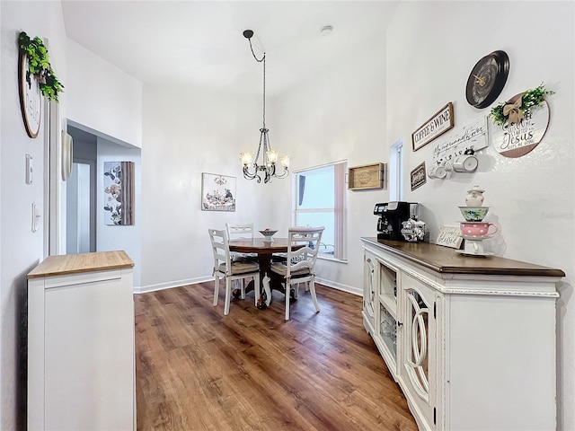 dining space with dark hardwood / wood-style floors and an inviting chandelier