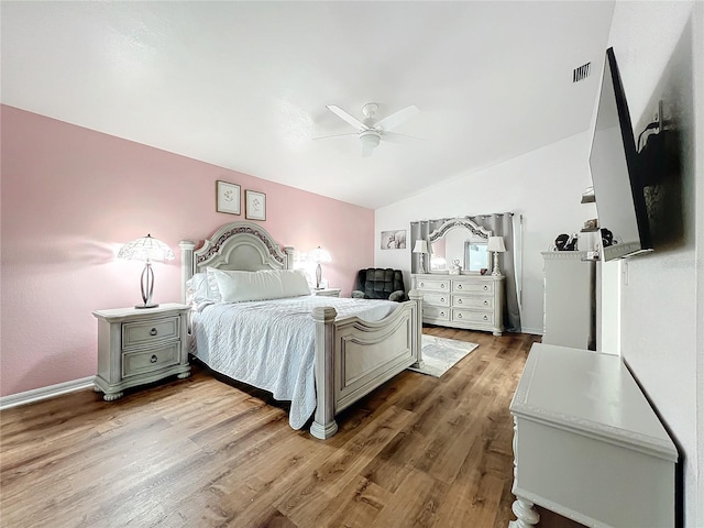 bedroom with light hardwood / wood-style floors, vaulted ceiling, and ceiling fan