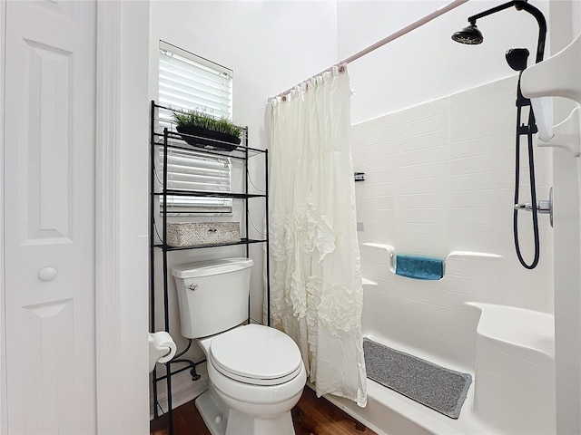 bathroom with hardwood / wood-style flooring, shower / bath combo, and toilet