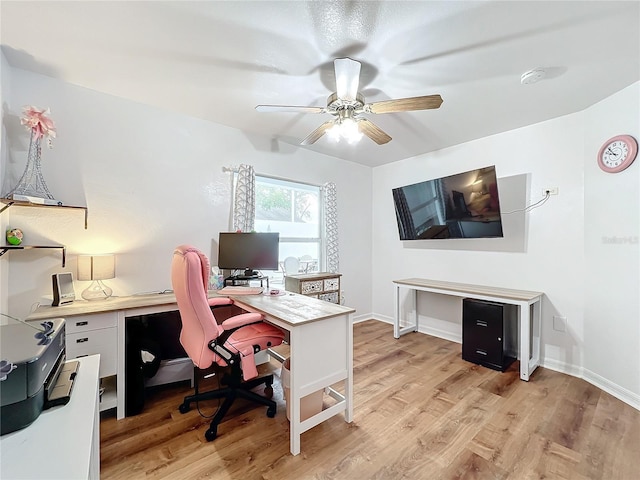 office with light wood-type flooring and ceiling fan