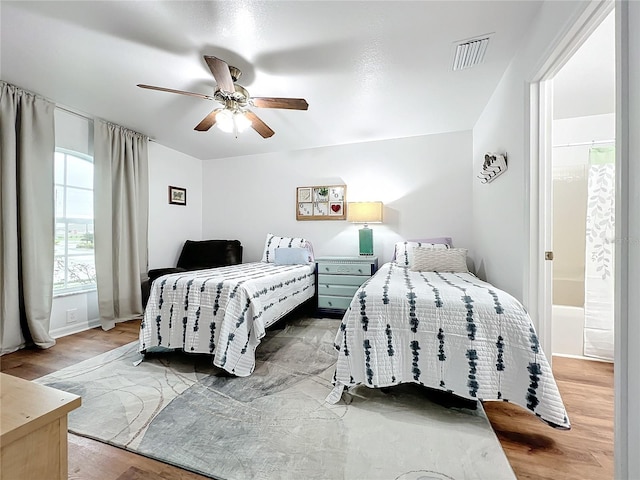 bedroom with ceiling fan, wood-type flooring, and ensuite bathroom