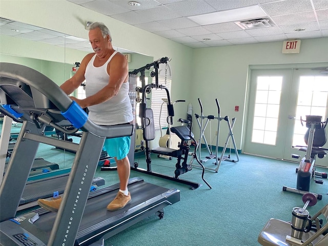 exercise room featuring carpet flooring and a drop ceiling