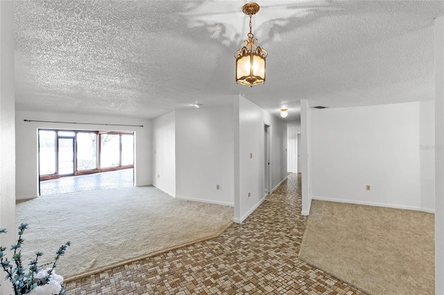 empty room featuring a chandelier and carpet