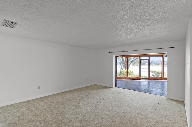 carpeted empty room with a textured ceiling