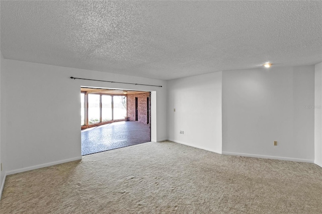 carpeted empty room with a textured ceiling