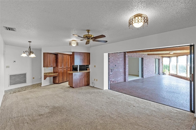 unfurnished living room with ceiling fan with notable chandelier, light colored carpet, and a textured ceiling