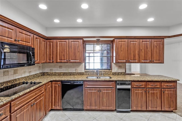 kitchen featuring light stone countertops, light tile patterned floors, black appliances, backsplash, and sink