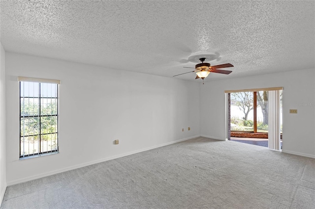 empty room with carpet floors, ceiling fan, and a textured ceiling