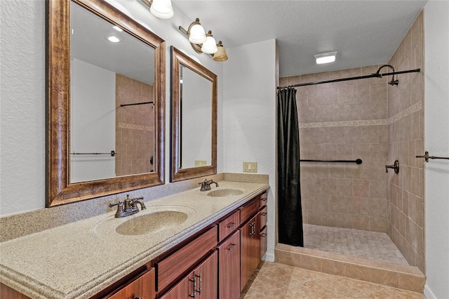 bathroom with a textured ceiling, curtained shower, tile patterned floors, and vanity