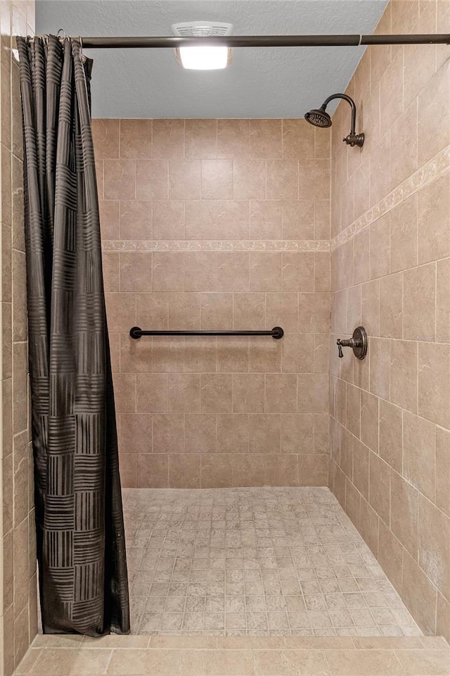 bathroom featuring a textured ceiling and walk in shower