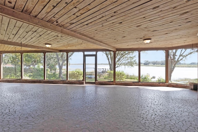 unfurnished sunroom featuring a water view, wooden ceiling, and vaulted ceiling with beams