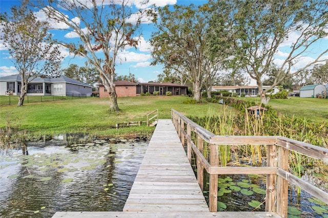 dock area with a yard and a water view