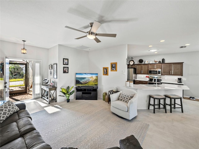 living room featuring ceiling fan and sink