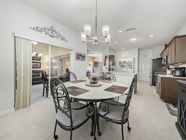 dining area featuring ceiling fan with notable chandelier