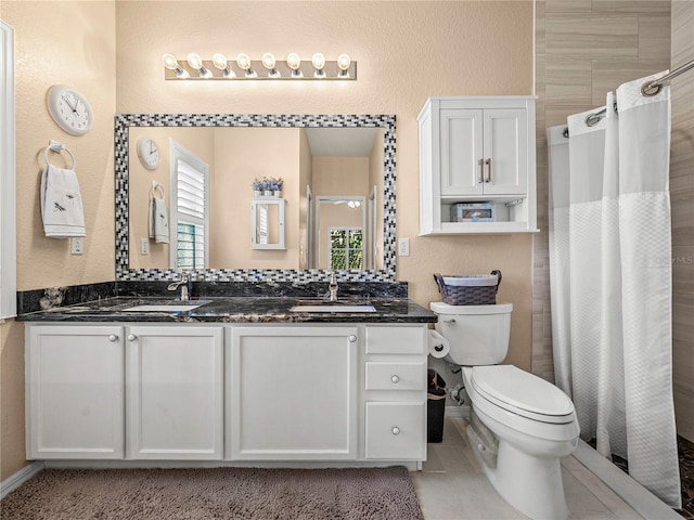 bathroom featuring curtained shower, tile patterned flooring, vanity, and toilet