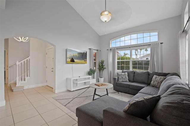 living room featuring ceiling fan, light tile patterned flooring, and high vaulted ceiling