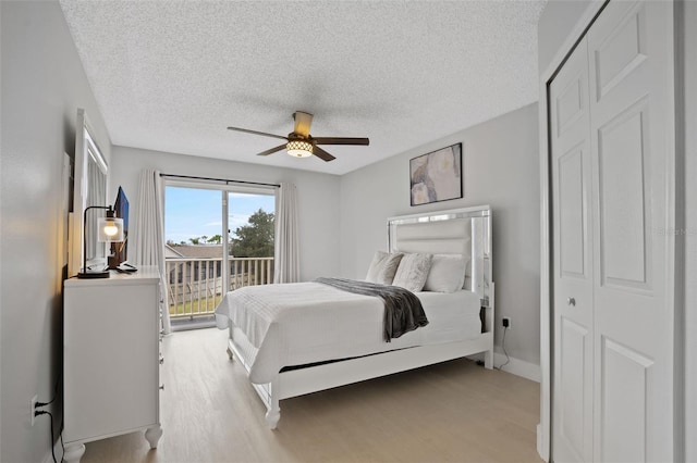 bedroom with ceiling fan, access to exterior, light wood-type flooring, a textured ceiling, and a closet