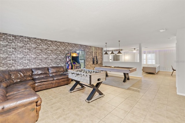 game room with ceiling fan, brick wall, light tile patterned flooring, and billiards