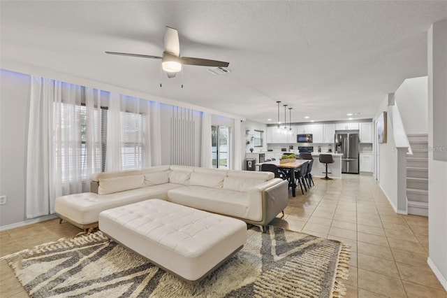 living room featuring ceiling fan and light tile patterned floors