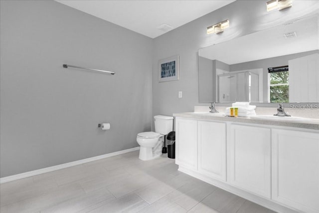 bathroom featuring vanity, toilet, and a shower with shower door