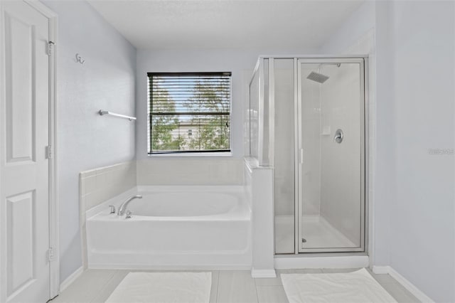 bathroom with tile patterned flooring, independent shower and bath, and a textured ceiling