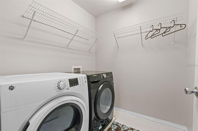 clothes washing area with washer and dryer and a textured ceiling