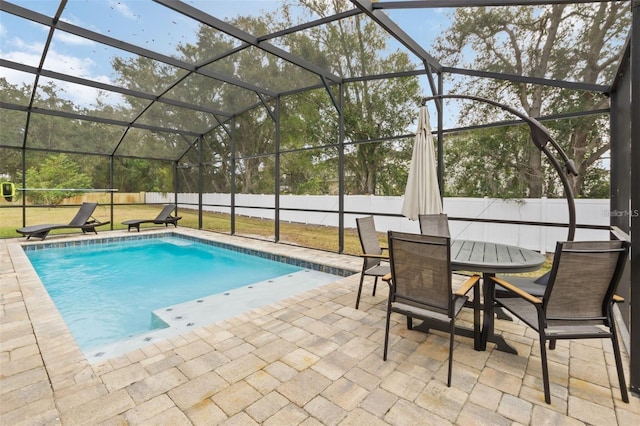 view of swimming pool with a lanai, a patio area, and a lawn