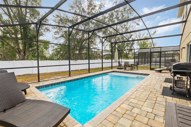 view of pool with a lanai, a patio, and grilling area