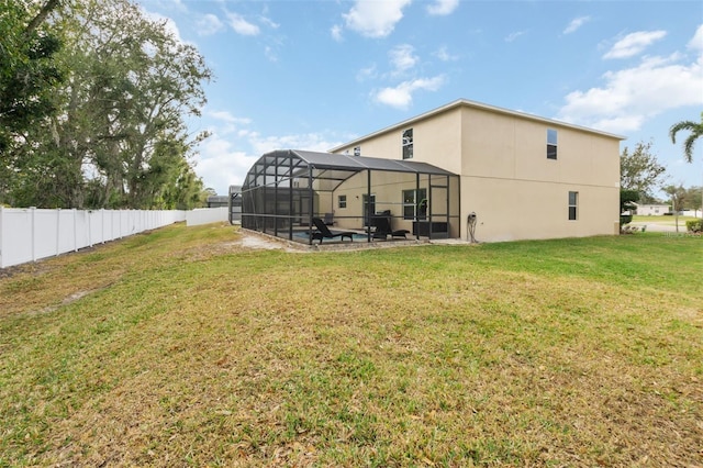 back of property featuring a lawn and glass enclosure