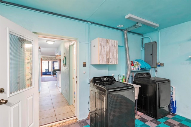 clothes washing area featuring tile patterned flooring, electric panel, and separate washer and dryer