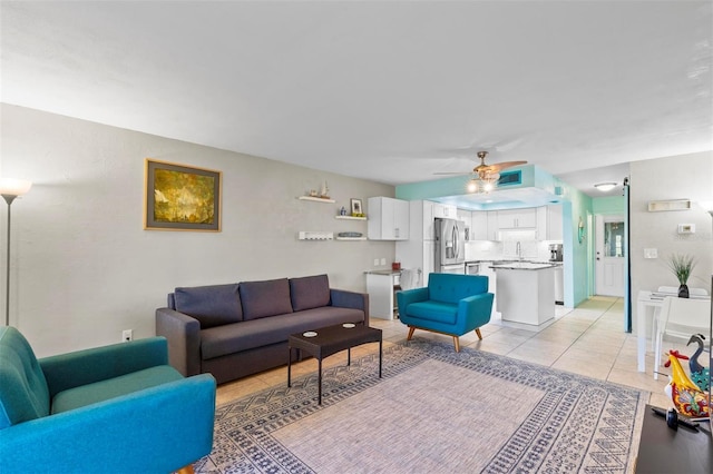 tiled living room with ceiling fan and sink