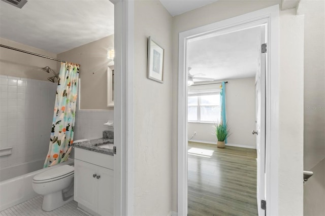 full bathroom with vanity, shower / bath combination with curtain, tile patterned flooring, ceiling fan, and toilet