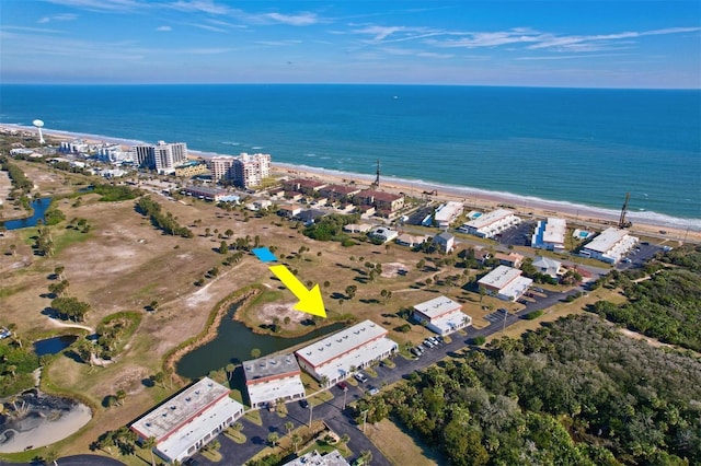 birds eye view of property with a water view and a beach view