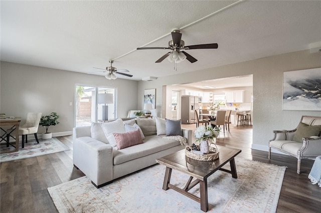 living room featuring ceiling fan, a textured ceiling, and hardwood / wood-style flooring