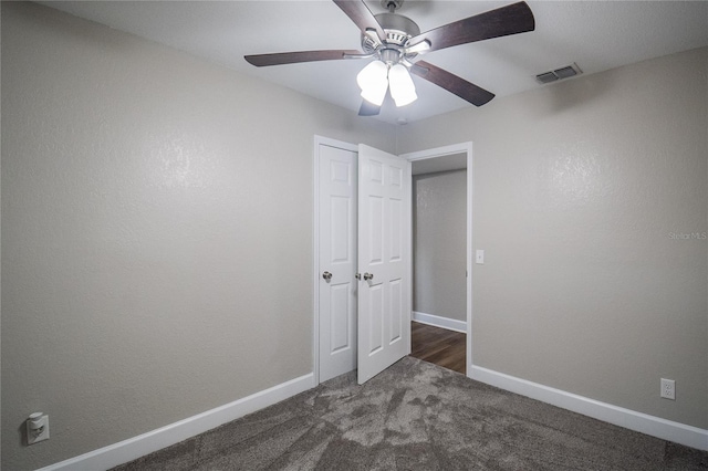 unfurnished bedroom featuring ceiling fan and dark carpet